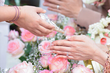 Fototapeta premium Close up pouring blessing water into bride's hands, Thai wedding