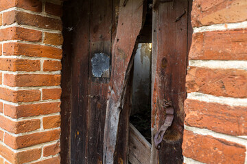 Old wooden doors in a destroyed building and a hole in them