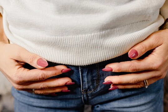 Woman hands on jeans pockets. Close up fingernails to exhibit nail polish.