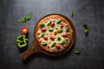 Top view of Italian food pizza with vegetables and herbs on a background