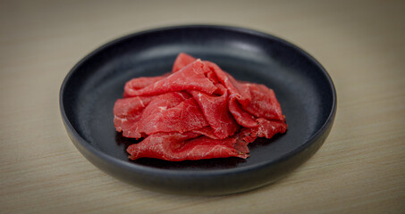 salted raw meet on the black plate