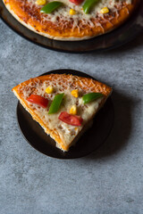 Top view of a slice of pizza on a plate with use of selective focus.