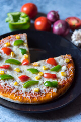 Close up of pizza with capsicum and tomatoes with use of selective focus.
