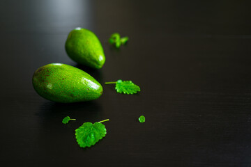 Fresh avocados with mint leaves on a black table. Concept of a hzalthy diet and healthy lifestyle. Vegan food. Detox drink