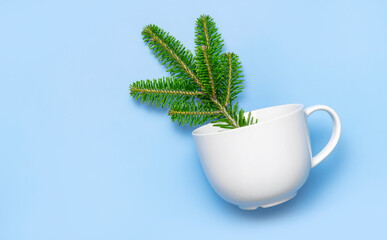 Christmas green fir branches, marshmallows, white ceramic cup on blue background flat lay top view copy space. Creative New year concept. Festive decor, celebration holiday card 2021