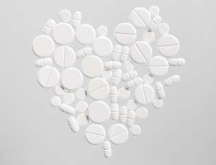 White medical pills in the shape of a heart