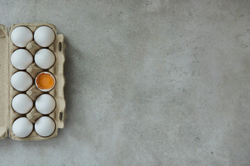 Eggs in an egg box, one of them opened
