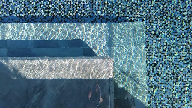 Top view of swimming pool water surface with sun light phenomenon.