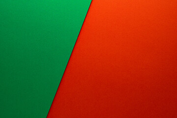 Beautiful background of two unequal parts of green and red paper. Sheets of blank green and red paper with fine texture devided  by a sloping border.