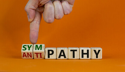 From antipathy to sympathy. Male hand turns cubes and changes the word 'antipathy' to 'sympathy'....