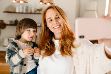 Mother taking a selfie with her son by mobile phone