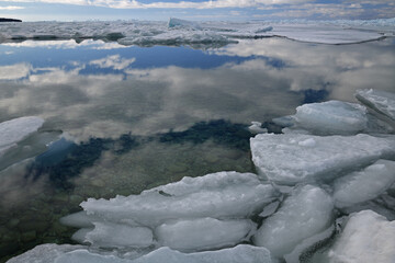 Landscape of blue ice shards with reflections in calm water, Straits of Mackinac, Lake Michigan, Michigan, USA