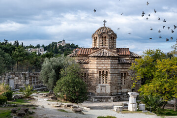 Greek Orthodox church in Thissio area, Athens, Greece. Flock of pigeons flying around the dome, ...