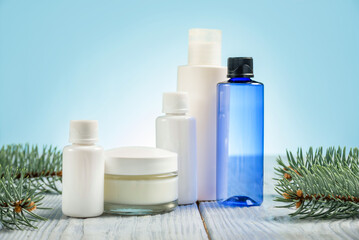 Containers of different sizes and colors for cosmetics on a blue background.