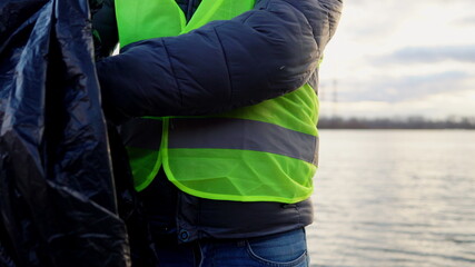 A volunteer on a city beach found a used condom and puts it in a garbage bag. Environmental...