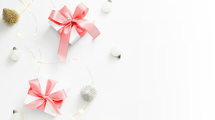 Happy new year. White gifts with scarlet bow, balls and sparkling lights in xmas decoration on white background for greeting card. Christmas, winter, new year concept.