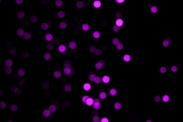 Blurry colored Christmas holiday lights on a black background.