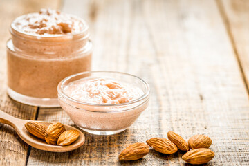 spa concept with almond nuts and scrub on wooden background