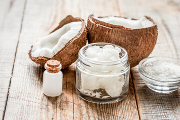 fresh coconut with cosmetic oil in jar on wooden background