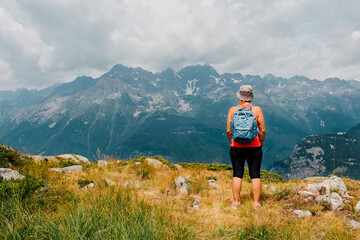 une femme regarde le paysage des alpes en été. un touriste dans les alpes regardant le paysage