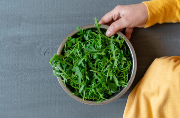 Plate arugula green hand yellow gray background copy space fortuna gold colour