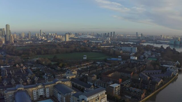 Dolly forward drone shot towards O2 arena over Isle of Dogs and river thames at sunrise London
