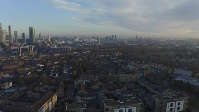 Dolly forward drone shot towards O2 arena over Isle of Dogs at sunrise London