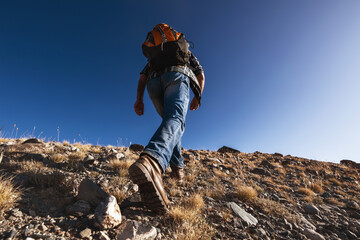 Unrecognizable male traveler goes uphill