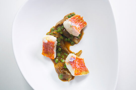 Grilled striped red mulled with artichokes and peas.