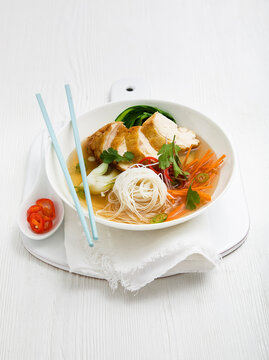 Chicken noodle soup with white thin noodles, Pak Choi, carrot, green chilli and coriander