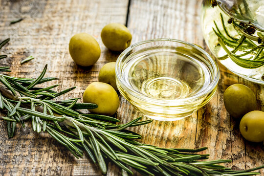 olive oil with ingredients on kitchen table background