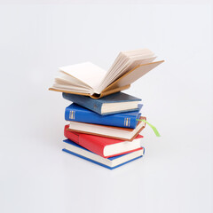 Stack of books in colour covers with white sheets isolated on a white background