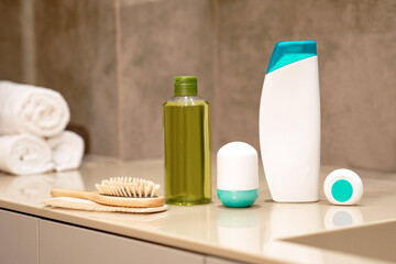 Hair care products on a wooden table on a neutral background.