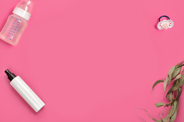 Baby bottle with nipple, pacifier, pump or spray bottle with no logo and green twig on pink studio background. Close up, copy space. Top view