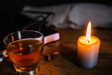 mesa de trabajo con taza de té alumbrado por una vela