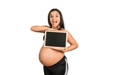 Pregnant woman showing something on chalkboard.