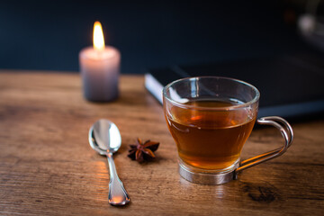 mesa de trabajo con taza de té alumbrado por una vela