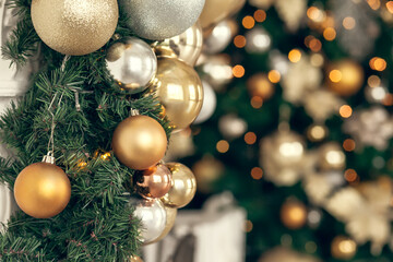 Gold and silver Christmas toys, balls garlands on a spruce branch