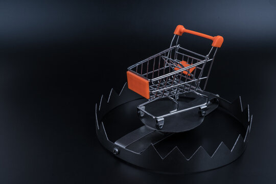 Trolley for shopping in a trap. Black Friday concept, discount prices cheat
