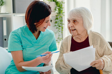 Therapist talking with old woman patient