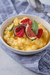 Pumpkin porridge with rice, raspberries and fresh figs. Autumn food.