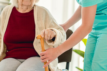 Nurse giving cane to old woman