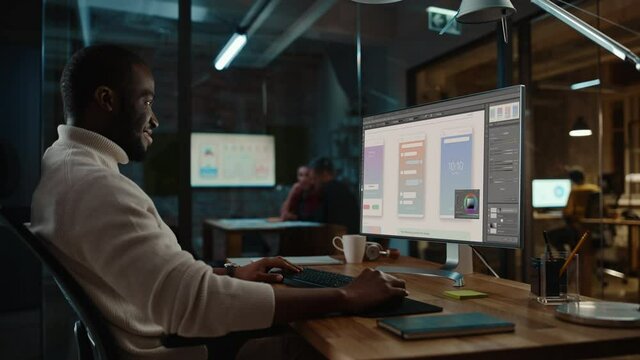 Handsome Black African American Working on Desktop Computer in Creative Office Environment. Person of Color is Developing a New App Design and User Interface in a Digital Graphics Editing Software.