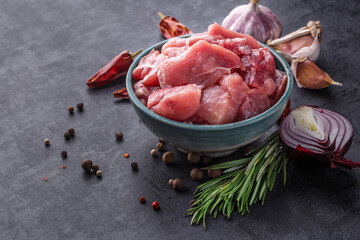 Shooting for the catalog.Bowl of chopped raw meat for a dog or cat on a rustic wood floor surrounded by fresh vegetables for a healthy animal diet
