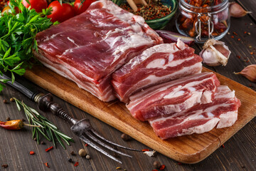 fat bacon on a wooden board. Close-up fat bacon with garlic and spices, homemade lard,Slices of bacon on a cutting Board. Pork meat.