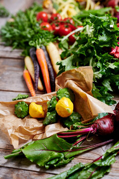 an arrangement of vegetables with beetroot, patty-pan squash, colourful carrots, tomatoes and mizuna
