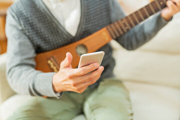 Fototapeta premium 家で楽器を弾くシニア男性