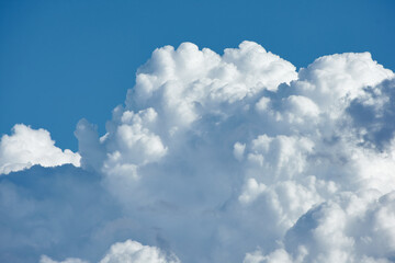 Naklejka na ściany i meble Detail of large clouds over a blue sky