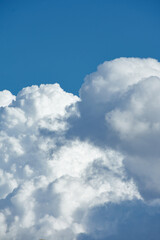 Naklejka na ściany i meble Detail of large clouds over a blue sky