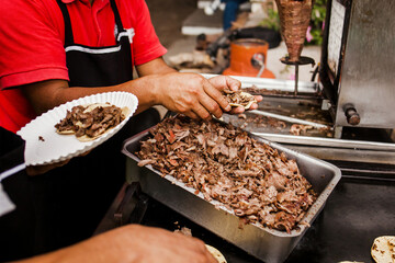 Taquero Mexican man preparing tacos al pastor in Taqueria in Mexico city